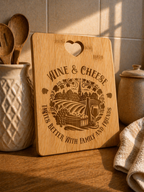 Engraved bamboo cheese board with wine and vineyard design styled in warm kitchen setting with utensils and soft lighting