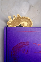 Wooden dragon bookmark inside of book with its head sticking out