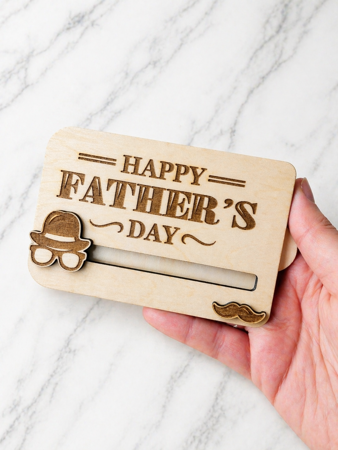 Wooden Father’s Day gift card holder held in hand showing size and engraved personalised design