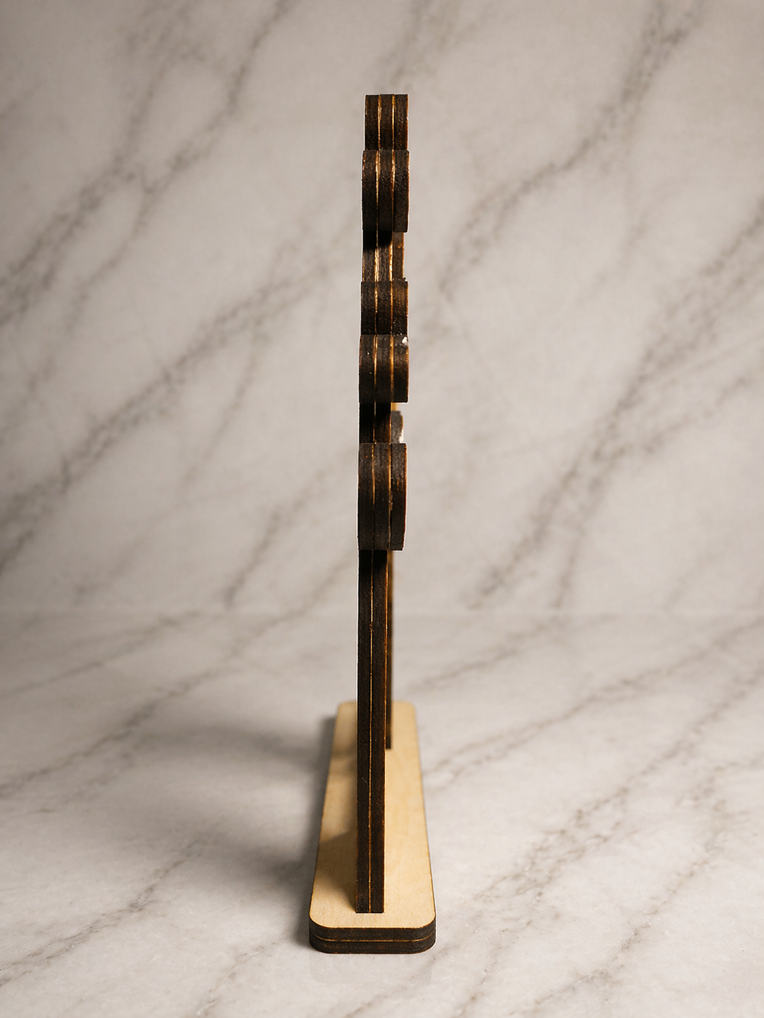 Side profile of personalised wooden tree swing ornament showing layered laser cut depth and base